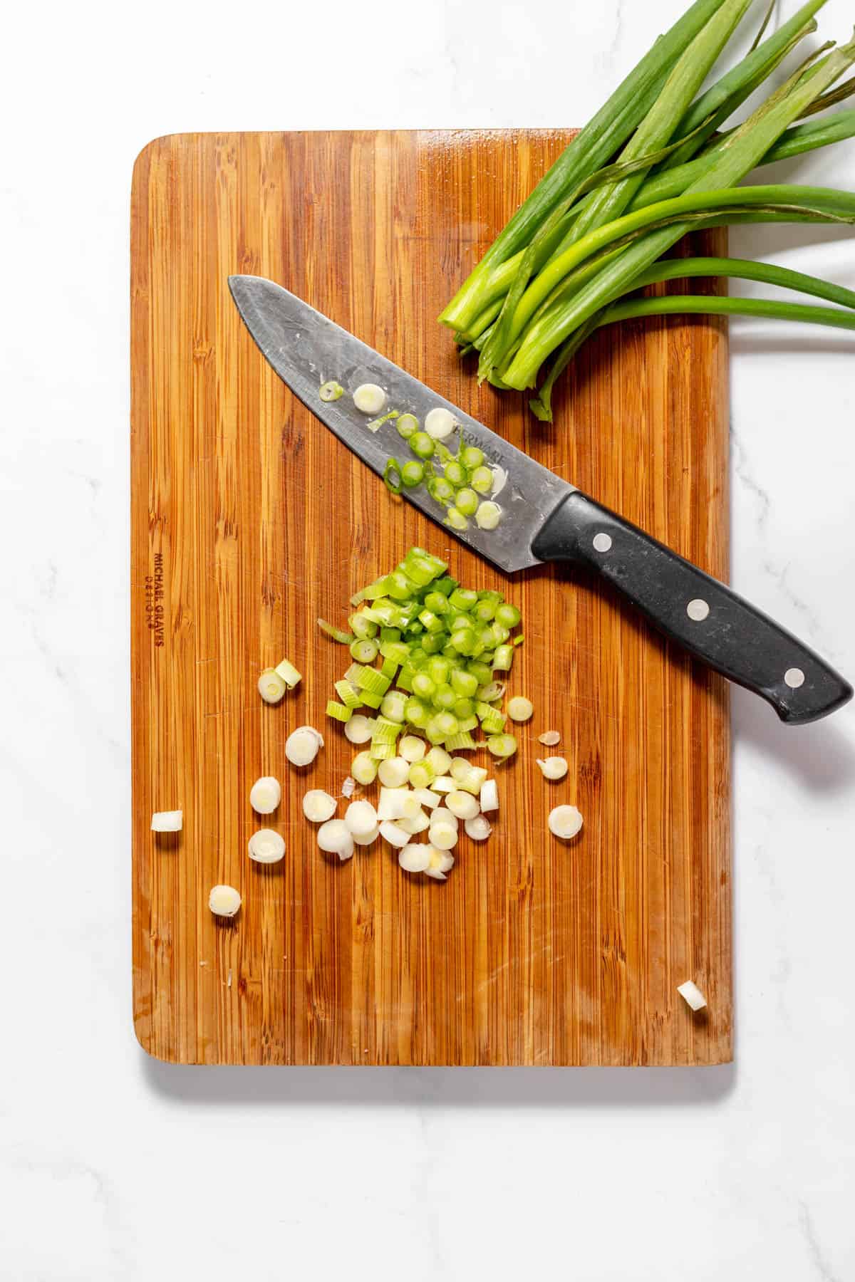 Chopping green onions on a cutting board.