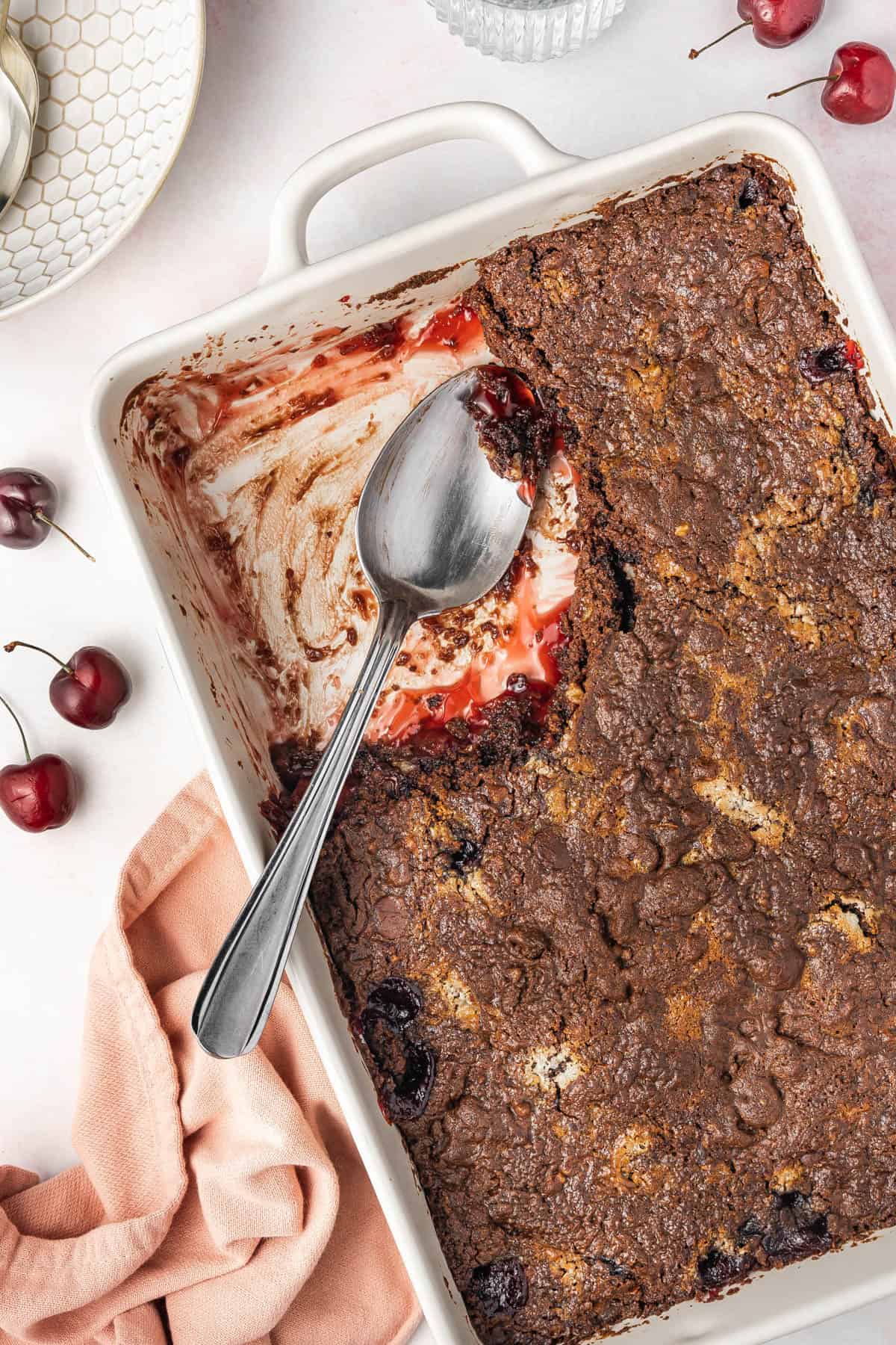 Chocolate cherry dump cake with a big serving removed from the baking dish.