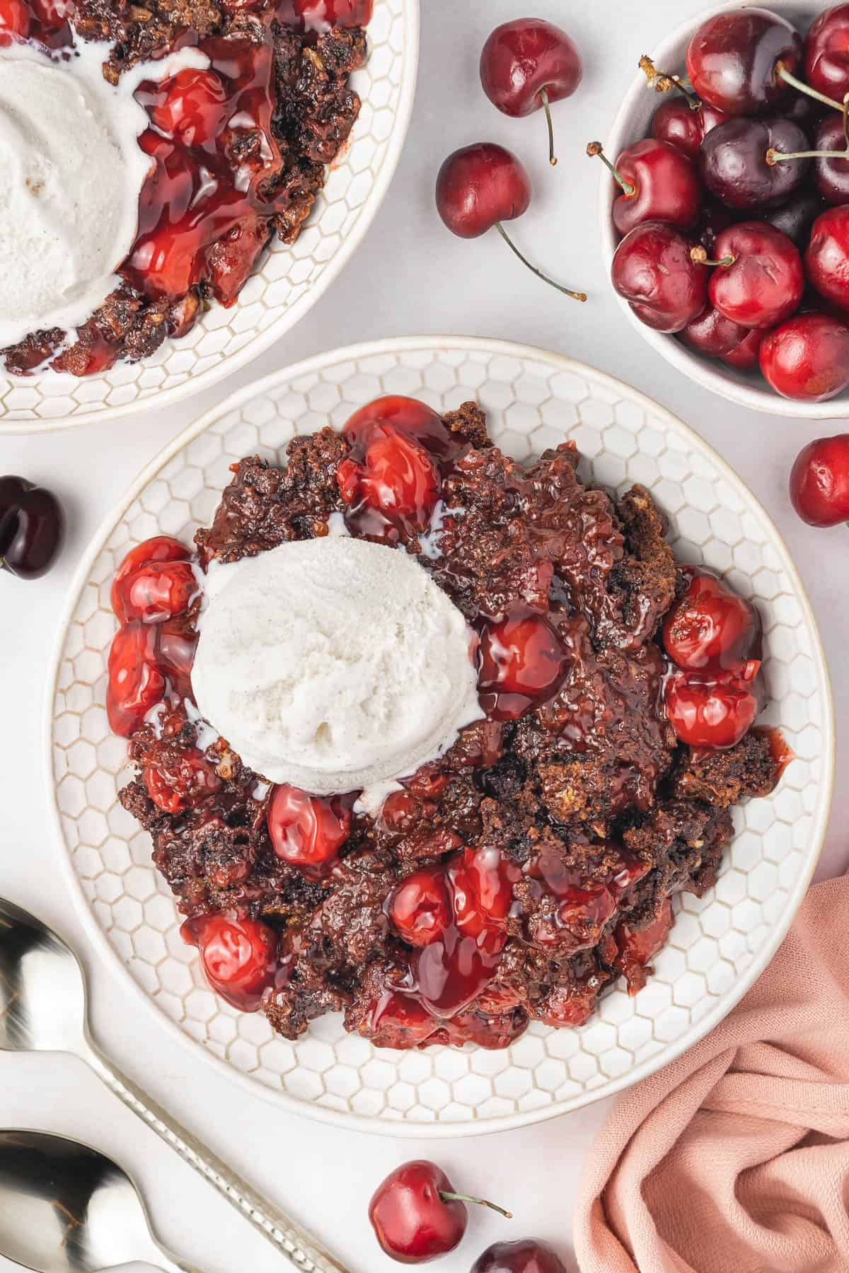 A large bowl of chocolate cherry cobbler with vanilla ice cream.