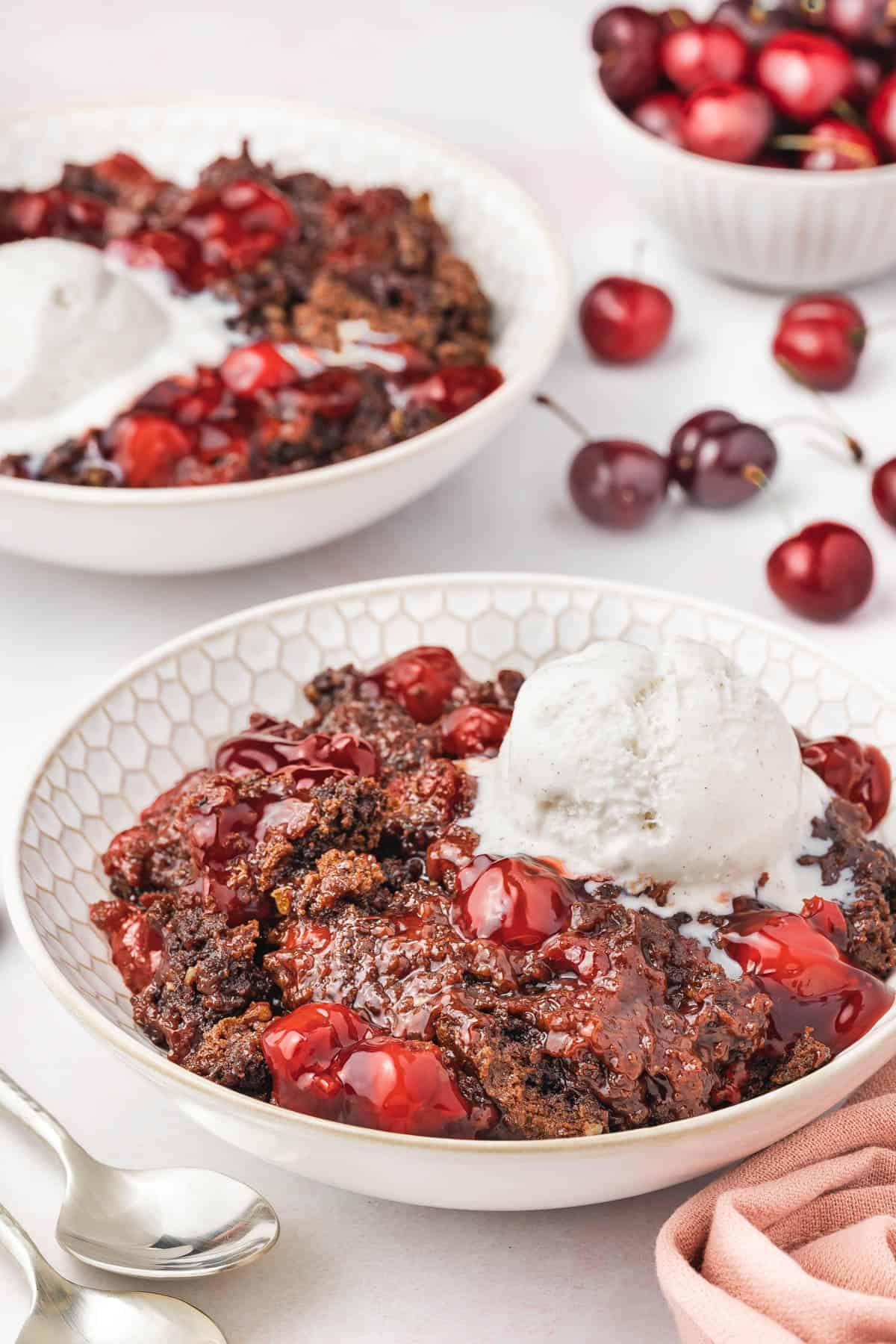 A side angle view of chocolate cherry dump cake in a bowl.