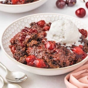 A side angle view of chocolate cherry dump cake in a bowl.