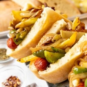 Homemade New Jersey Italian hot dogs topped with peppers, onions, potatoes, and yellow mustard.