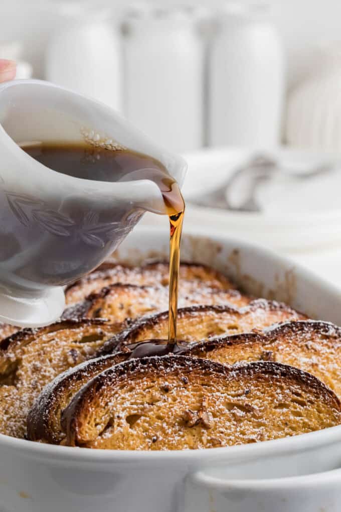 Maple syrup being poured over baked overnight French toast.