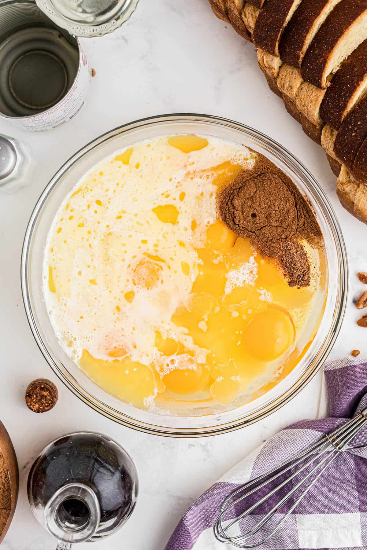 Combining eggs, milk, and ground cinnamon in a large bowl.