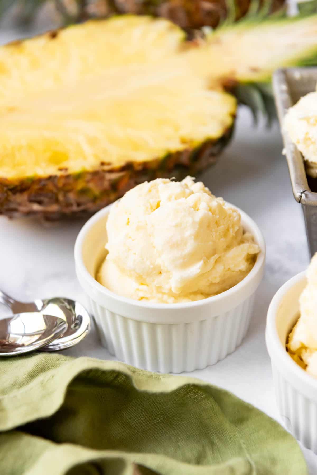A close up image of a scoop of pineapple ice cream in a bowl.