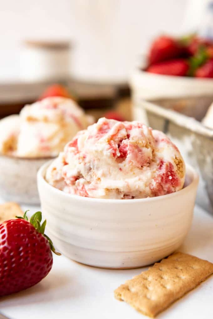 A white bowl filled with Strawberry Cheesecake Ice Cream.