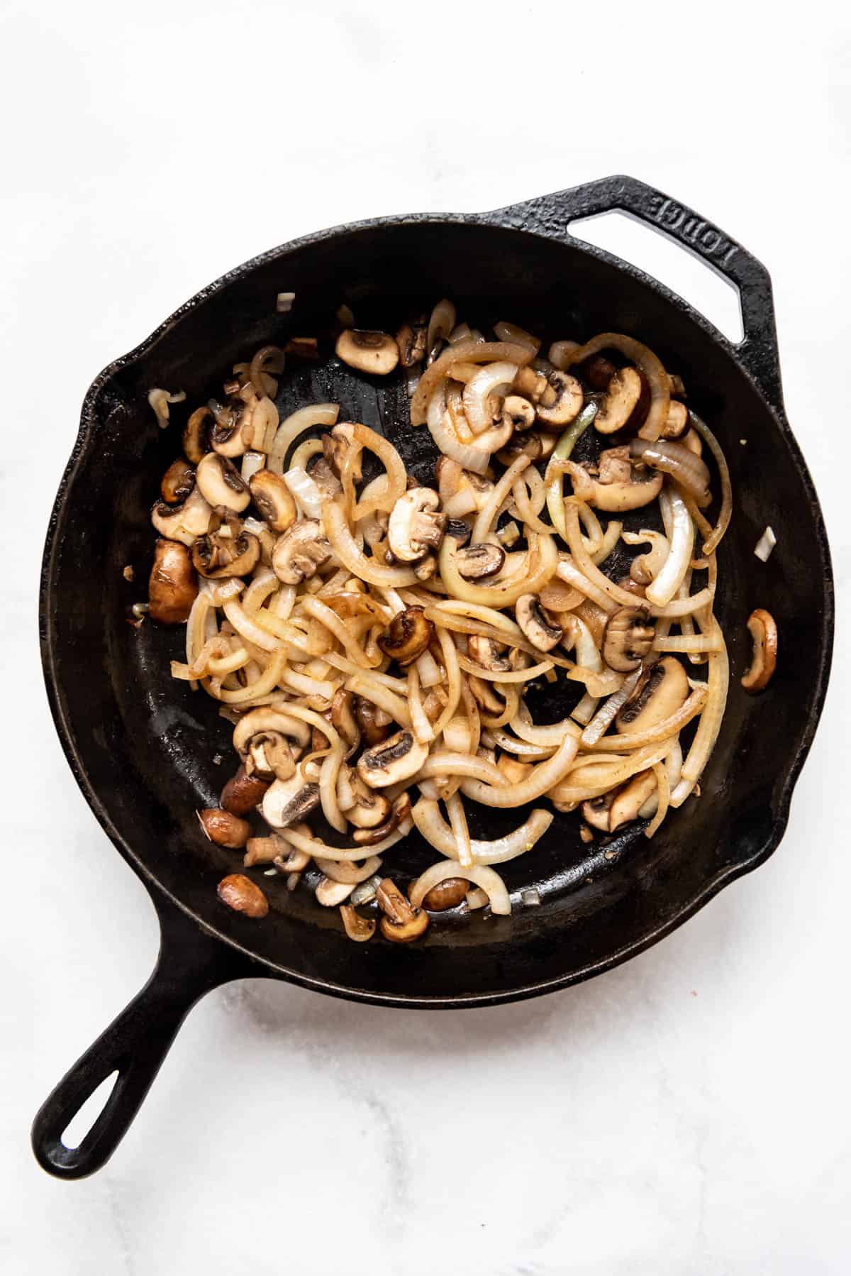 Sauteed mushrooms and onions in a large cast iron skillet.