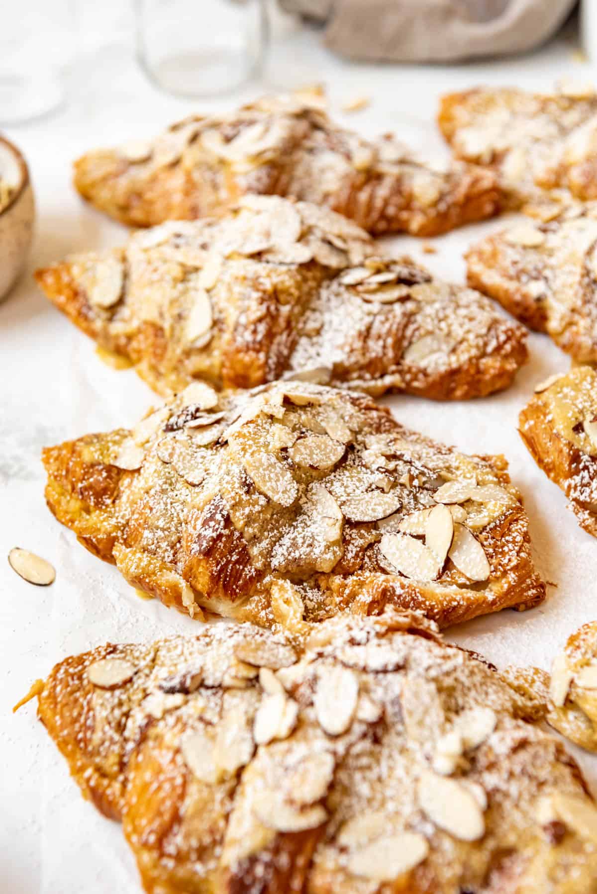 Fresh almond croissants dusted with powdered sugar.
