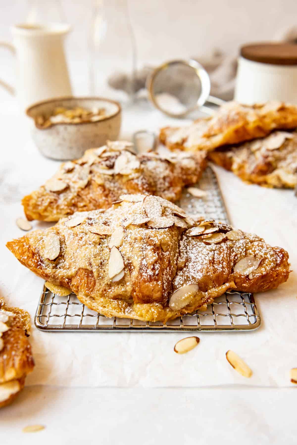 Almond croissants on a wire rack.