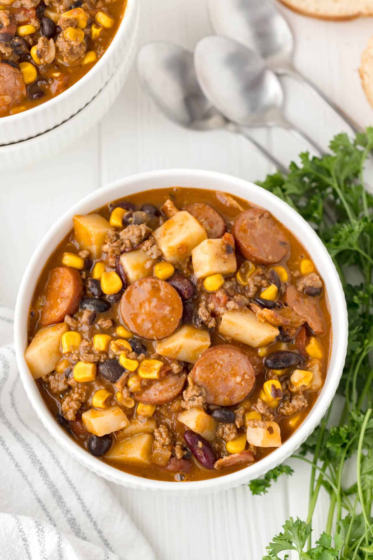 Bowls of cowboy stew with potatoes, ground beef, and smoked sausage.