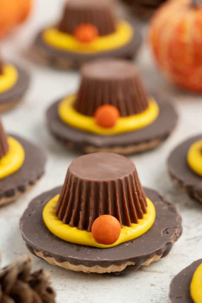 A pilgrim hat cookie with a Reese's peanut butter cup, frosting, and fudge-stripe cookies.