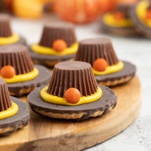 Pilgrim hat cookies on a wooden surface.