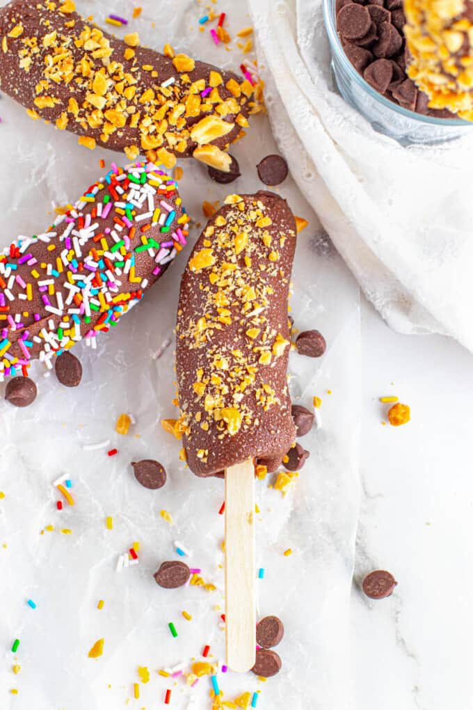 Chocolate banana pops with sprinkles and chopped peanuts.