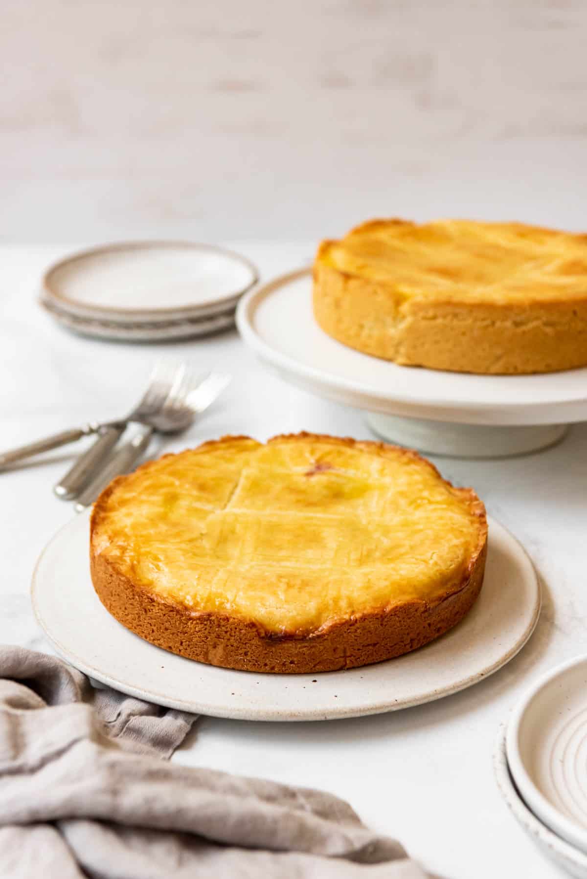 Two Basque cakes on plates next to each other.