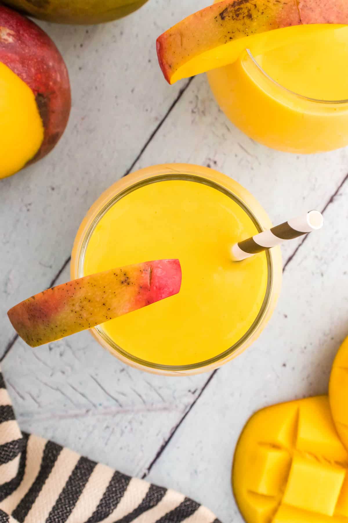 An overhead image of a glass of mango lassi.