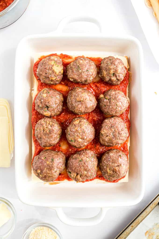Meatballs on cheese, sauce and buns for sliders.