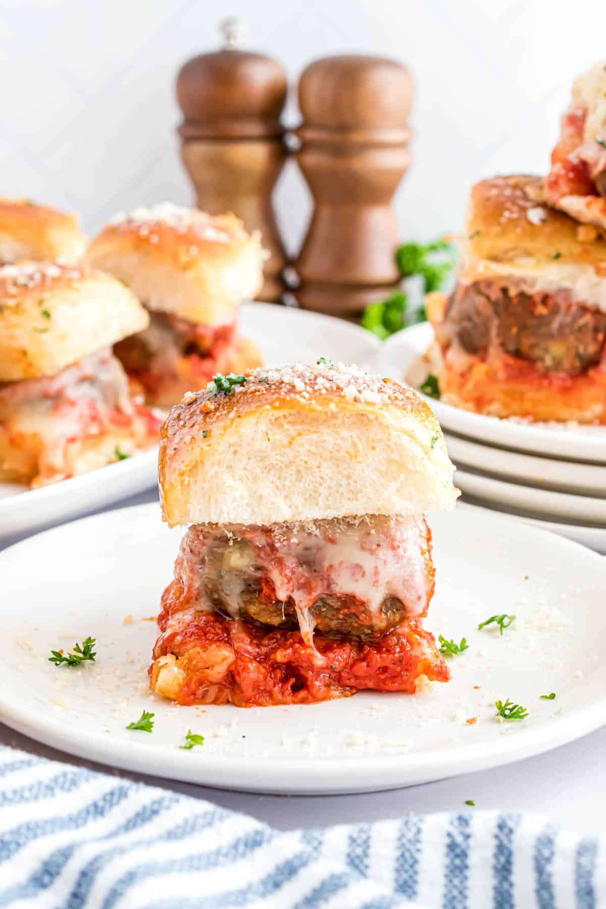 A meatball slider on a white plate.