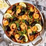 An overhead image of a large skillet of mixed Spanish seafood paella.