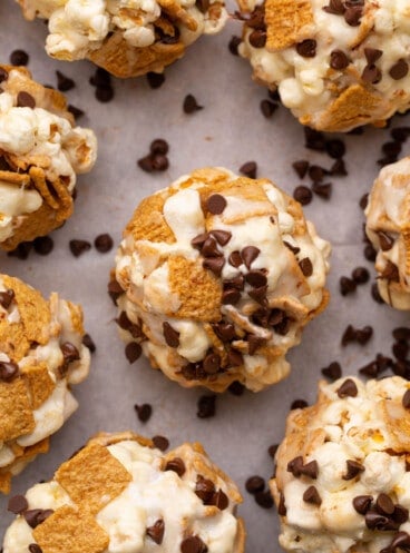A close image of s'mores popcorn balls made with golden grahams cereal, popcorn, and mini chocolate chips.