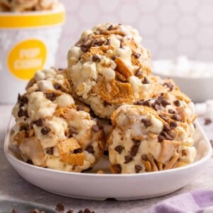 Stacked s'mores popcorn balls on a white plate.