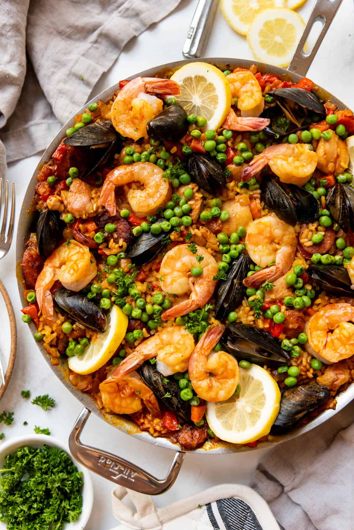 An overhead image of mixed Spanish paella with shrimp, mussels, chicken, and chorizo.