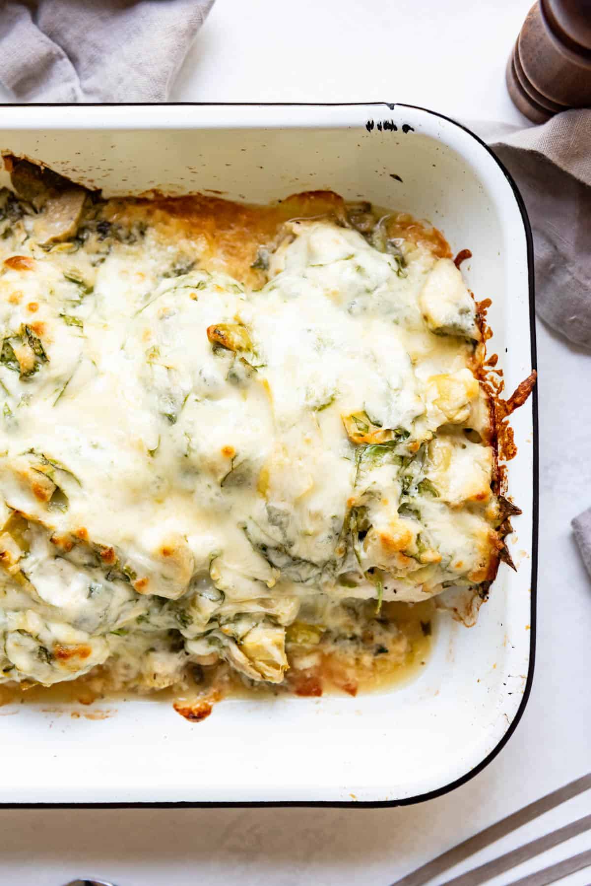 Baked spinach artichoke chicken in a pan.