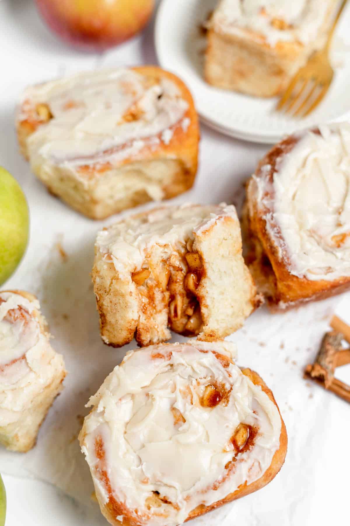 An image of apple cinnamon rolls with a bite taken out of one of them.