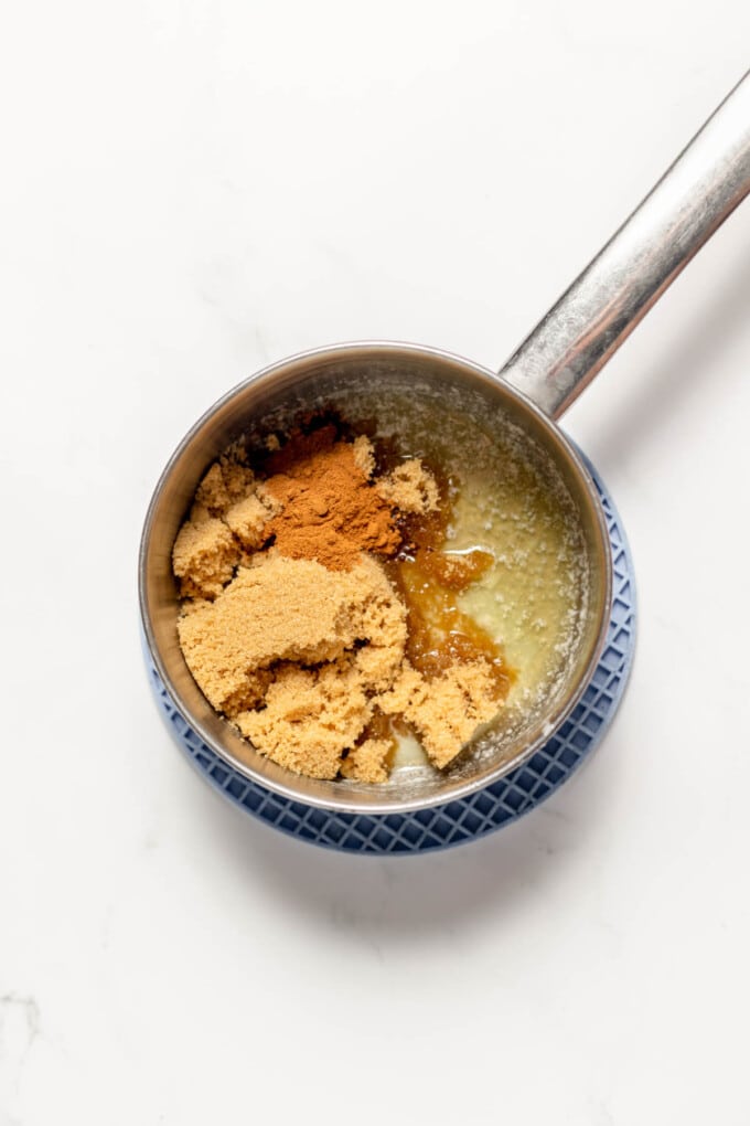Combining melted butter, cinnamon, and brown sugar in a saucepan.
