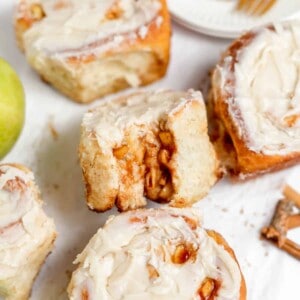 An image of apple cinnamon rolls with a bite taken out of one of them.