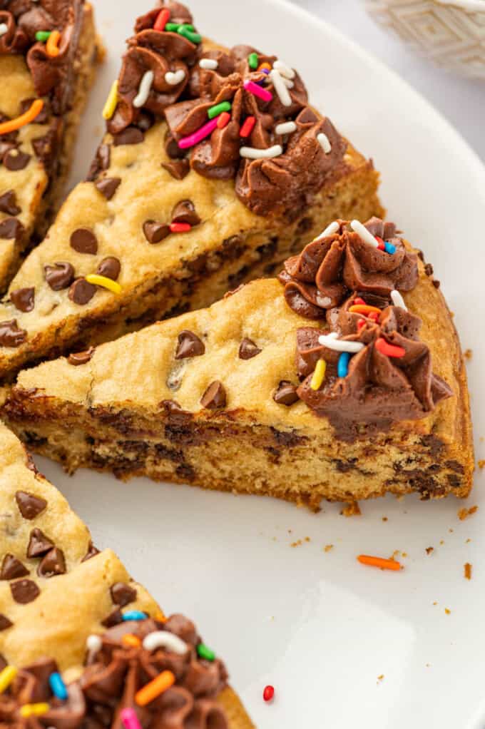 Slices of chocolate chip cookie cake on a white plate.