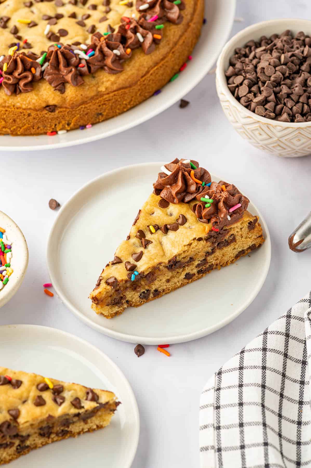 A slice of chocolate chip cookie cake on a white plate.