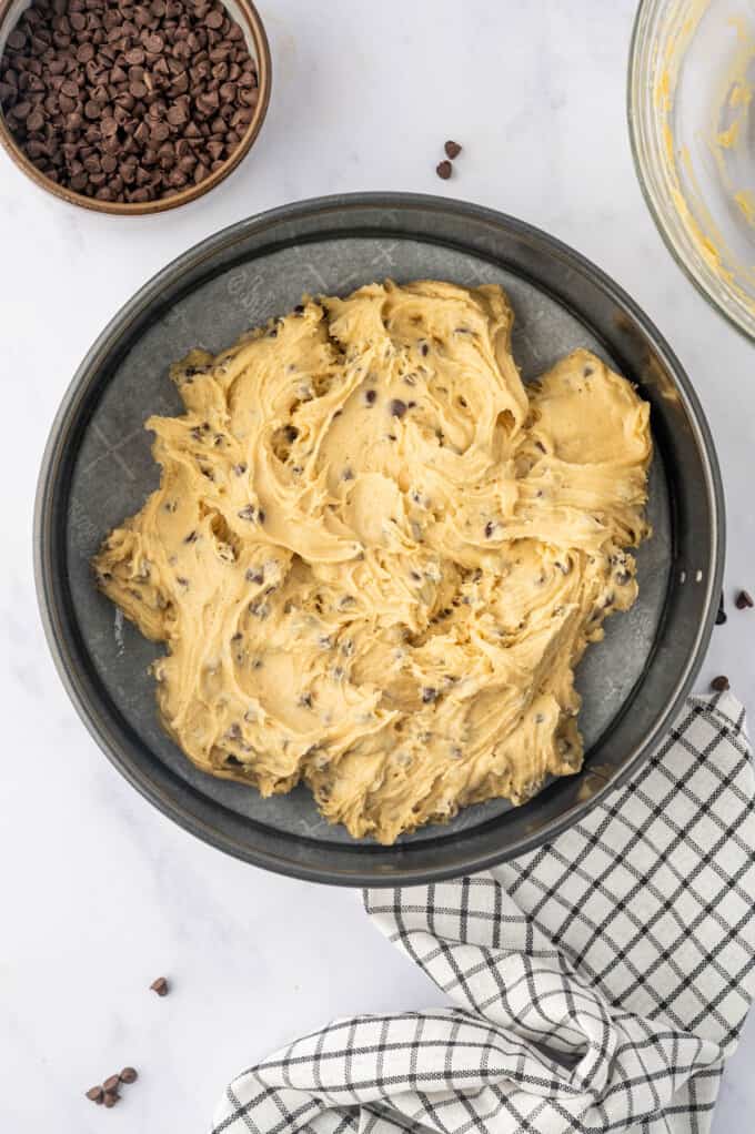 Spread chocolate chip cookie dough into a 9-inch round cake pan.
