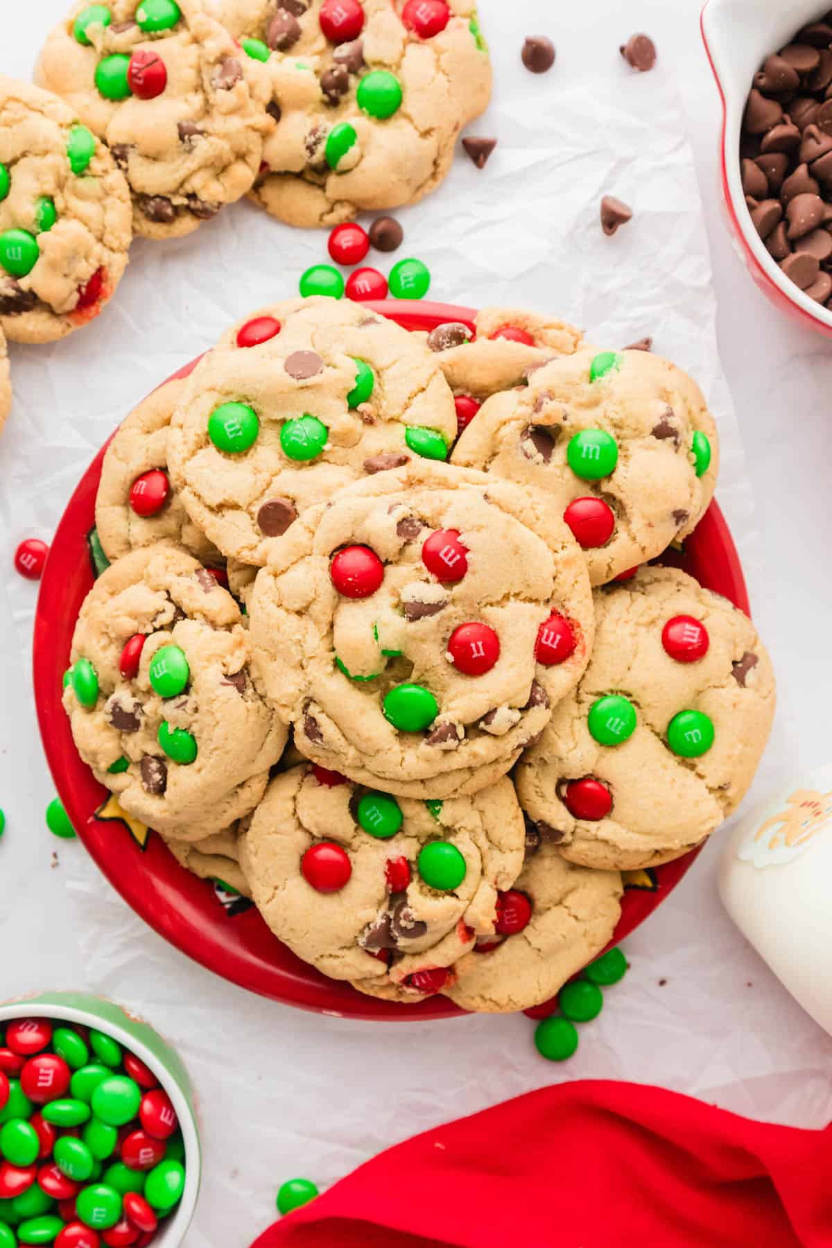 A red plate filled with Christmas cookies with red and green Christmas M&Ms.