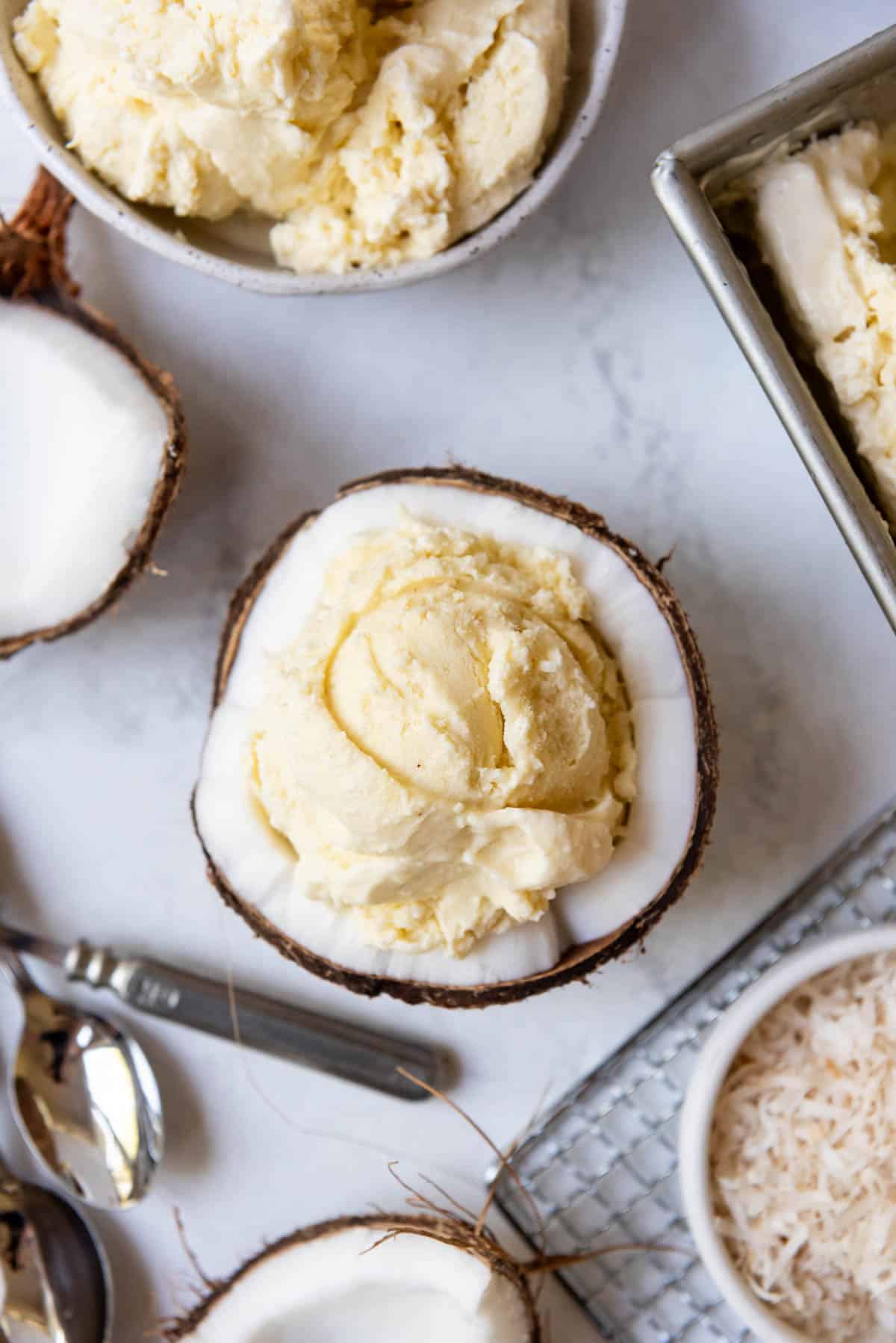 An overhead image of a scoop of coconut ice cream in a coconut bowl.