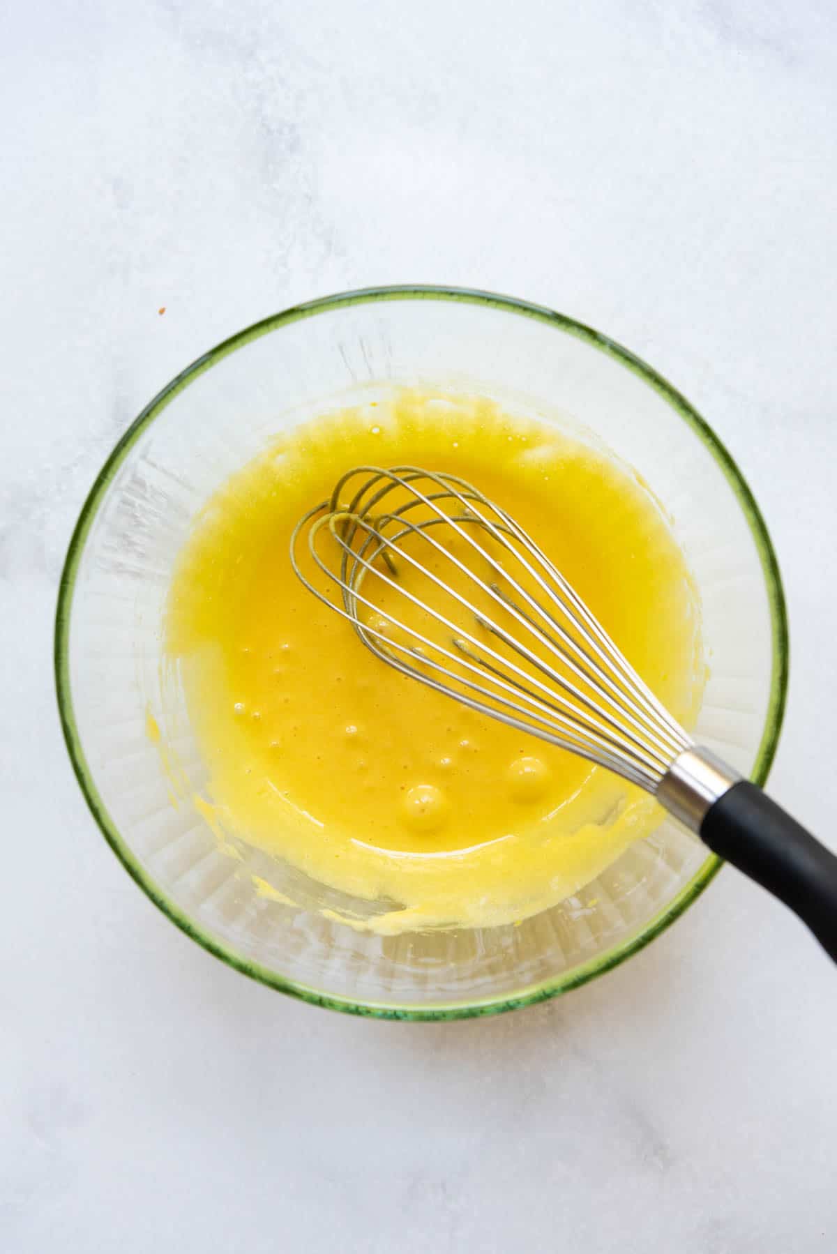 Whisked egg yolks and sugar in a bowl.