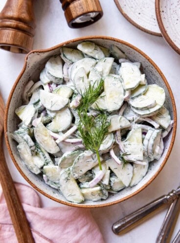 An overhead image of a bowl of creamy German cucumber salad.