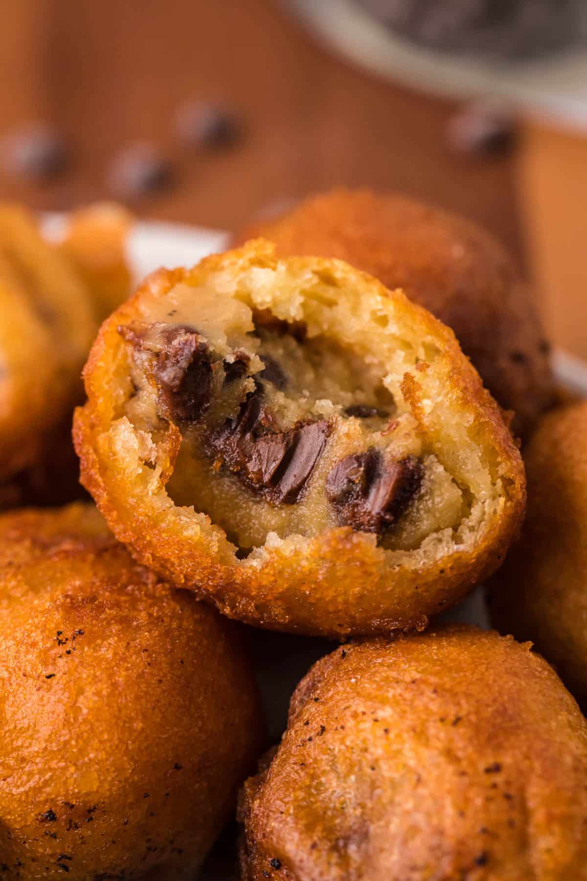 A close shot of cookie dough fried in batter with a bite taken out of it.