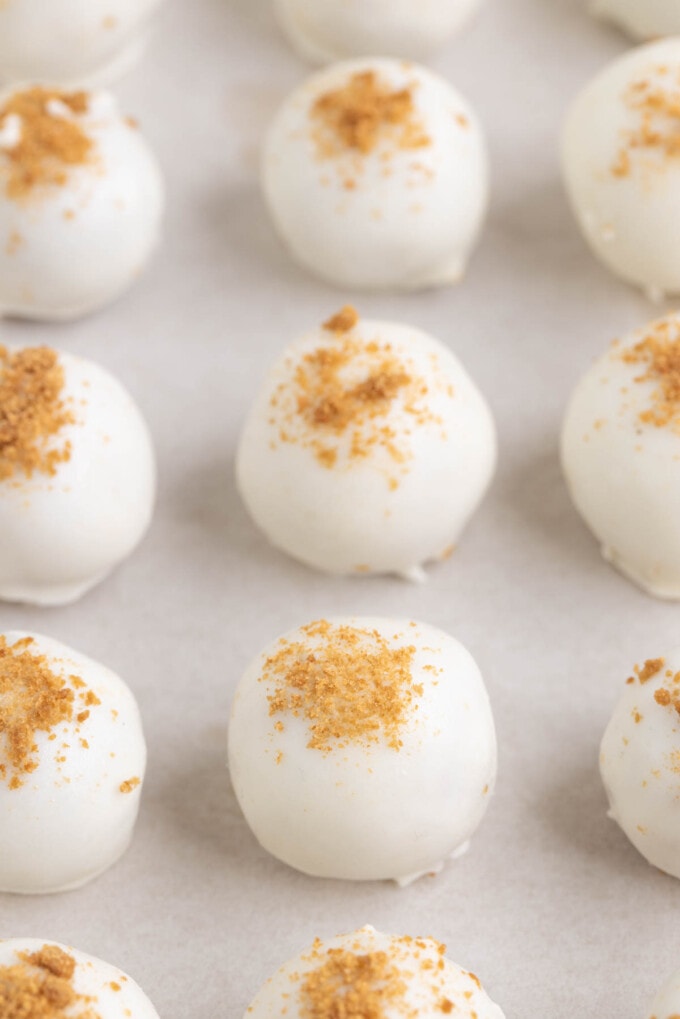 A close image of gingerbread truffles covered in white chocolate and crushed gingersnap cookie crumbs.