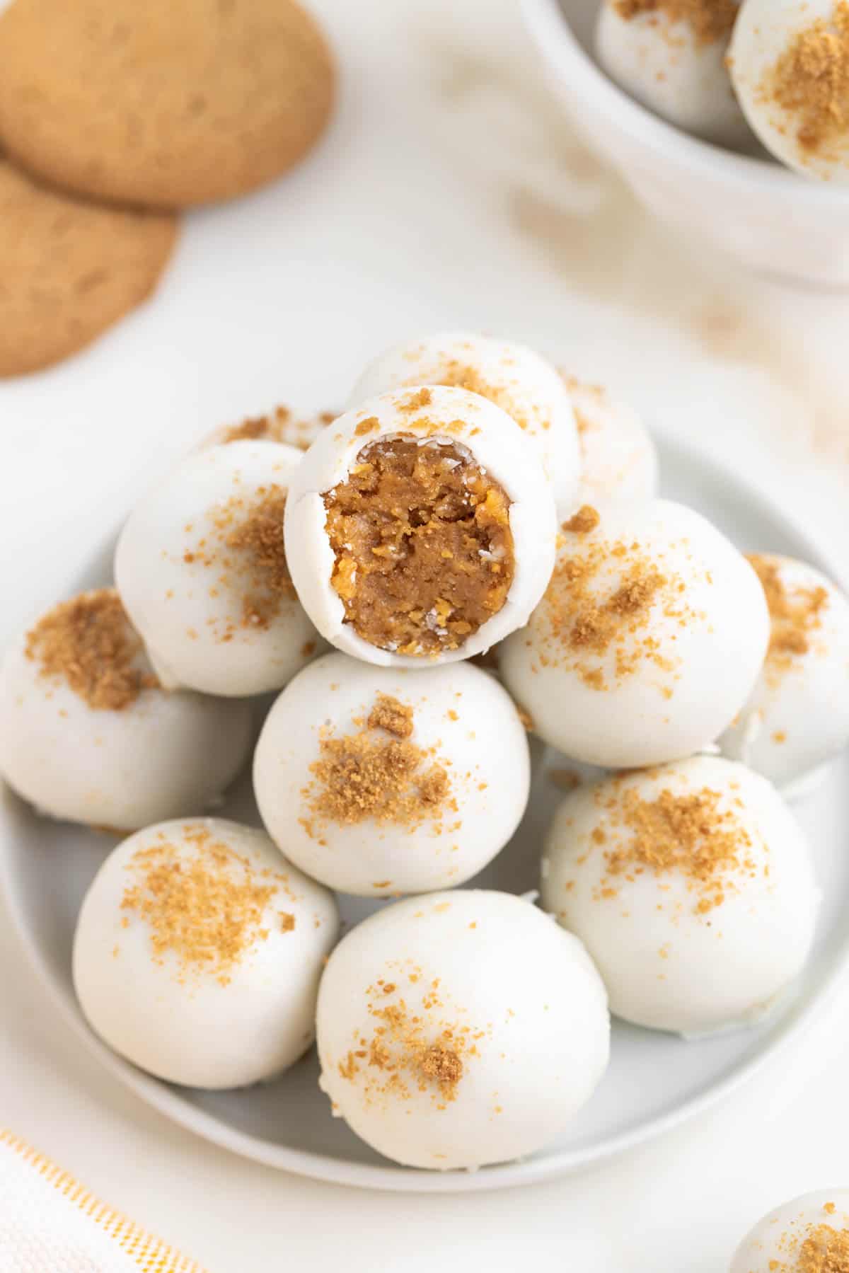 A plate of gingerbread truffles with a bite taken out of the top one.