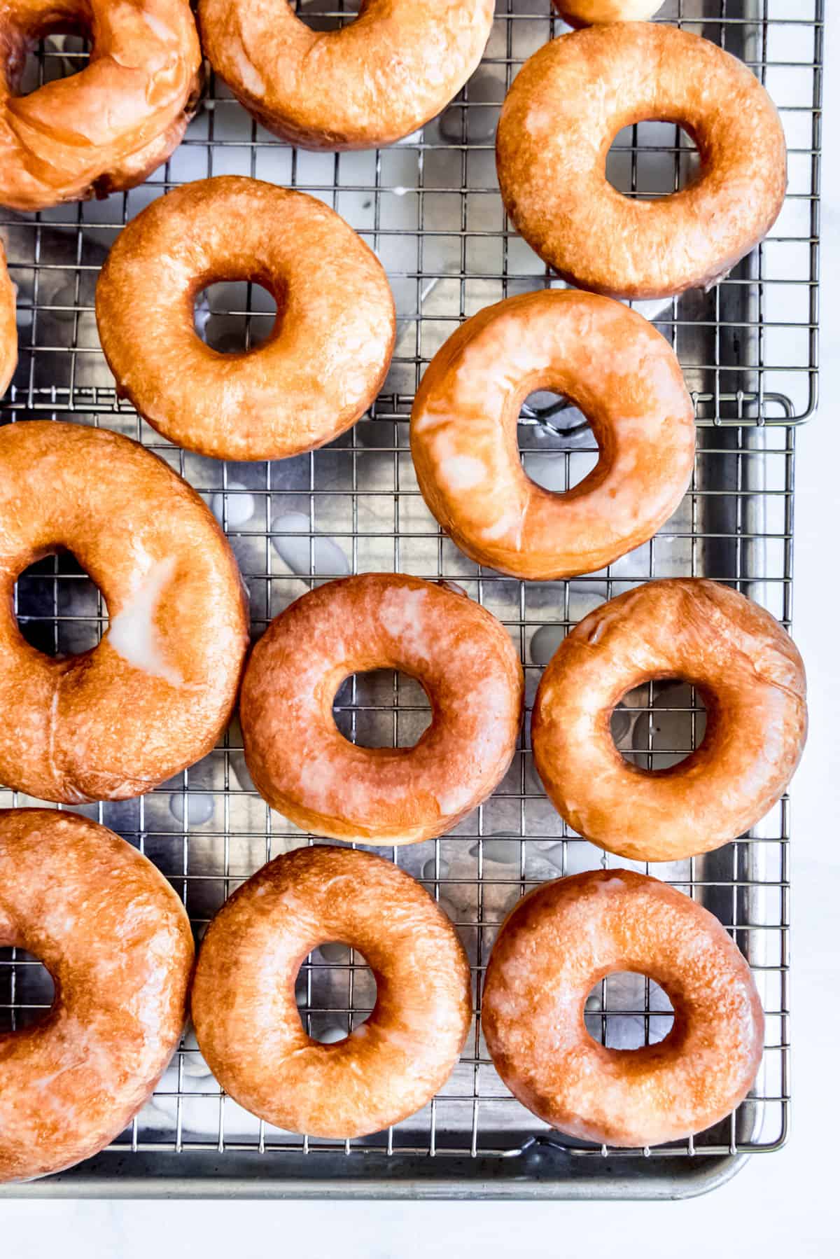 An overhead image of freshly made homemade glazed donuts.