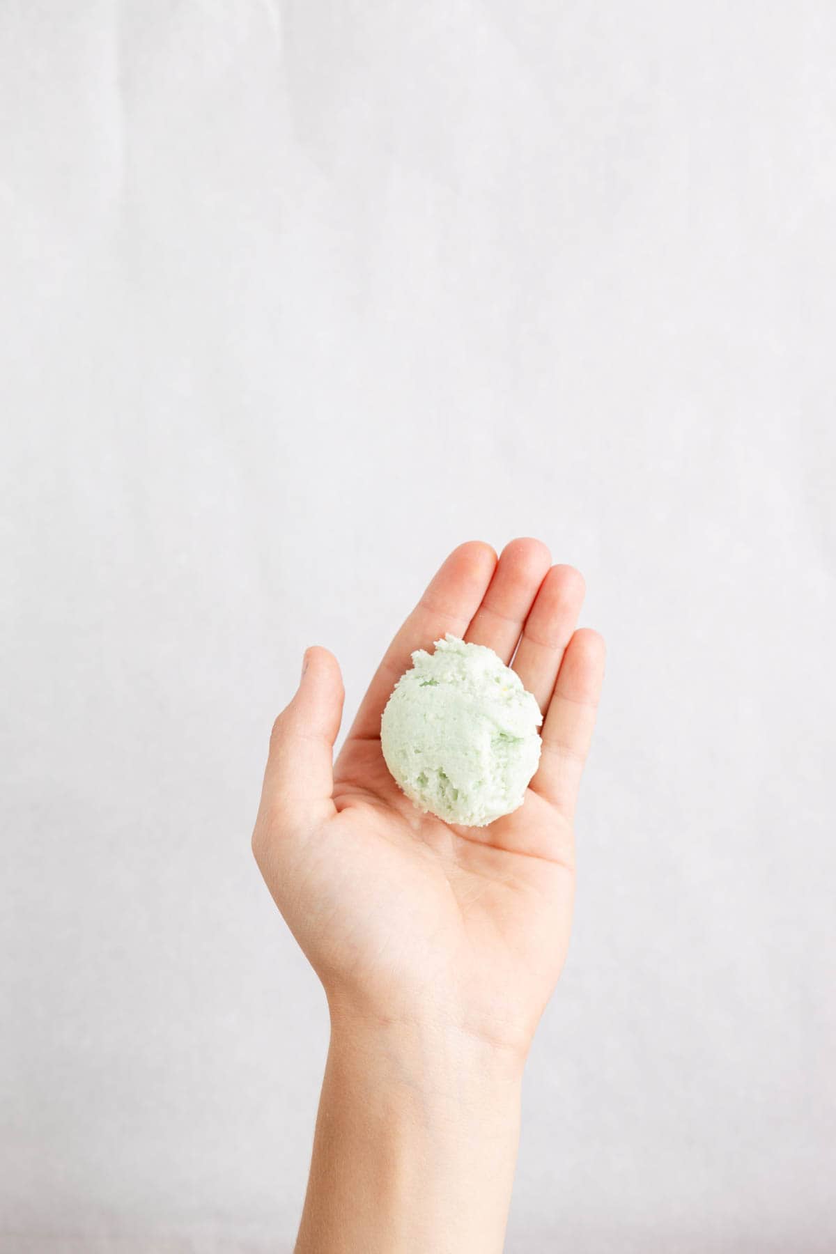 Rolling cookie cake pop centers in a hand.