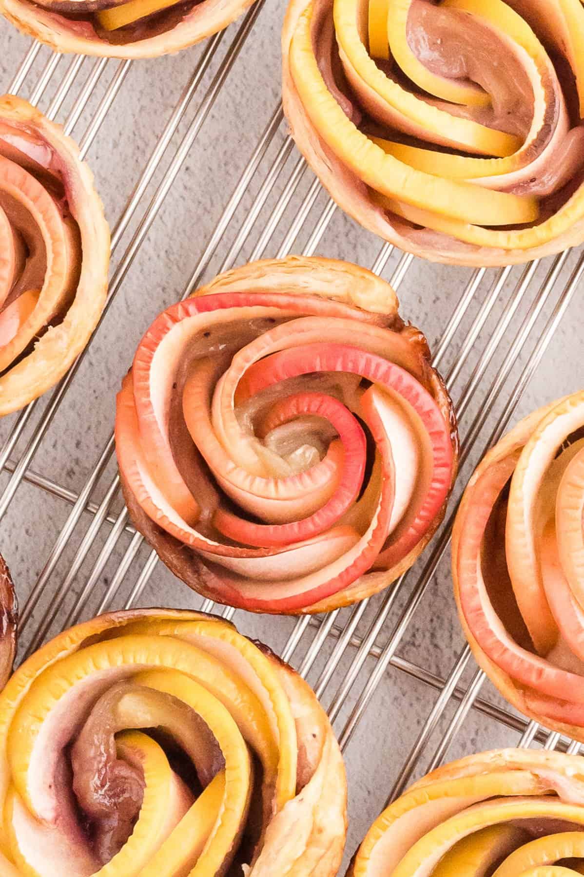 An overhead image of puff pastry apple flowers made with red and green apples.