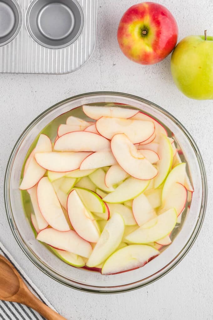 Soaking thinly sliced apples in water to prevent browning.