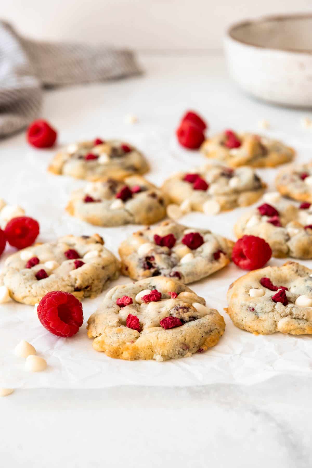 An image of raspberry cheesecake cookies on white parchment paper.