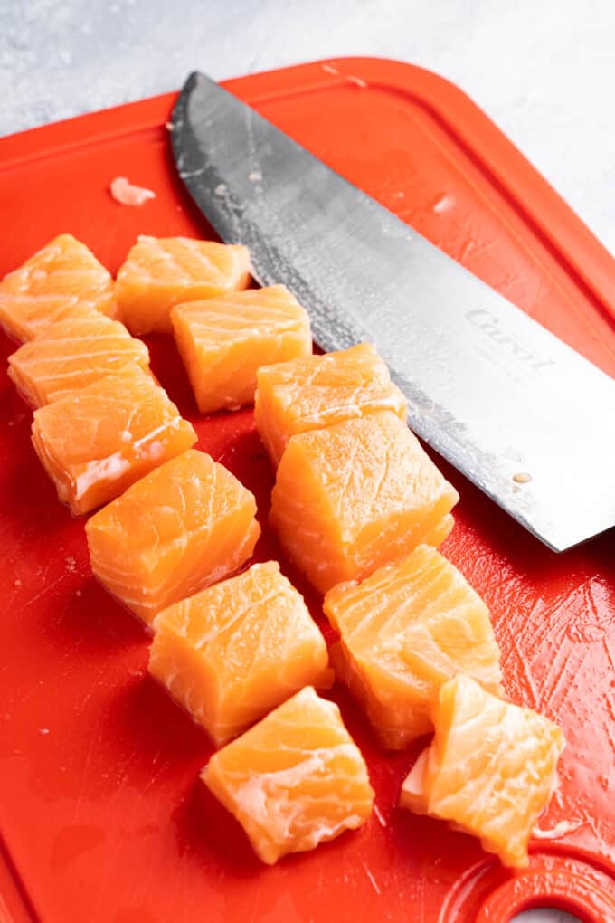 Cubing salmon into bite-size pieces.