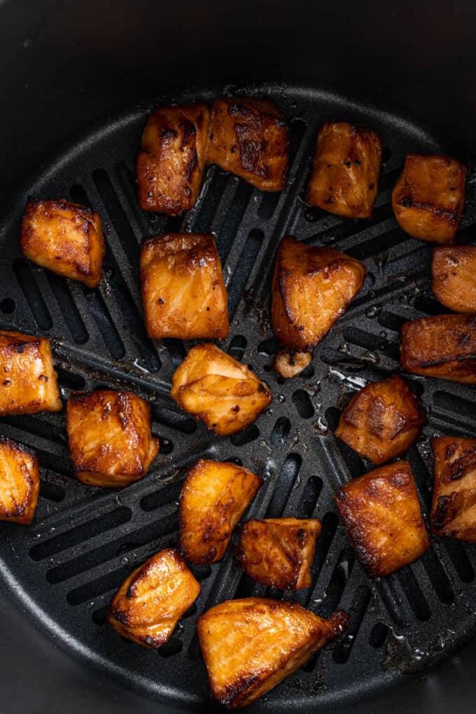 Cooked air fryer salmon bites in the air fryer basket.