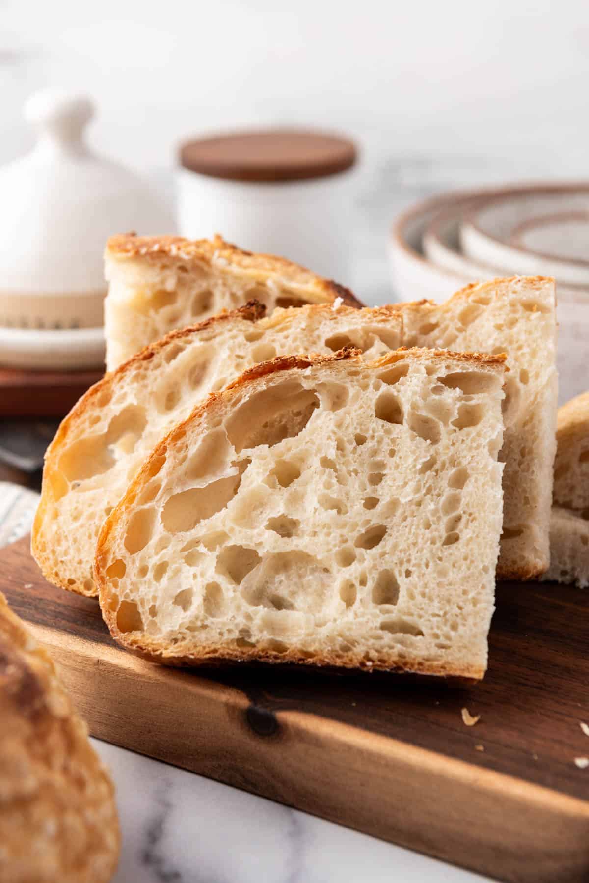 Slices of sourdough bread on a wooden cutting board.