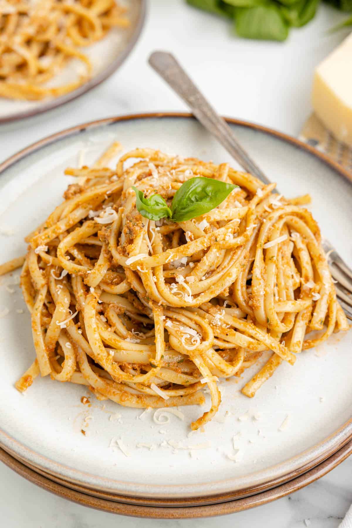 An image of pasta tossed with sun-dried tomato pesto.