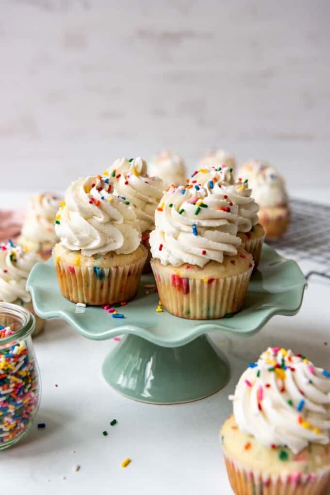 Sprinkle cupcakes on a pale green cake stand.