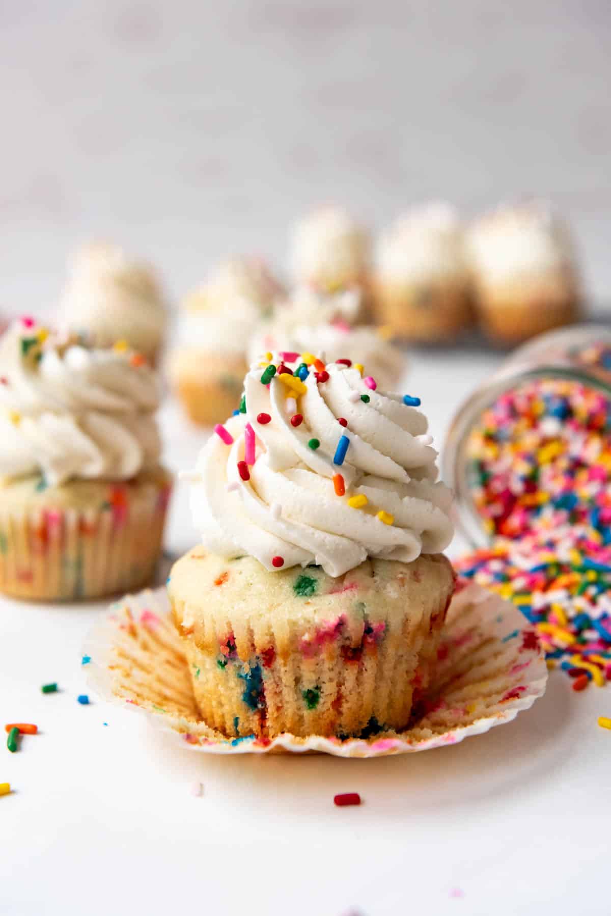 A homemade funfetti cupcake that has been unwrapped from its paper wrapper.
